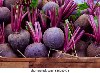 Fresh harvested beetroots in wooden crate, beets with leaves in the market - Powered by Shutterstock