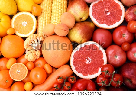 Fresh harvested yellow, red and orange fruits and vegetables from market: corn and orange, tomato and lemon, apple and pear, grapefruit and carrot