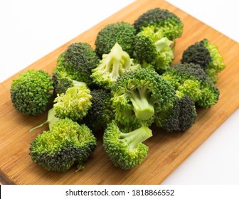 fresh healthy broccoli and florets on wooden board