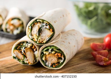 Fresh healthy chargrilled tandoori chicken wrap with tzatziki, cheese, baby spinach and carrots 