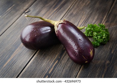 Fresh healthy eggplants on dark wooden background. 