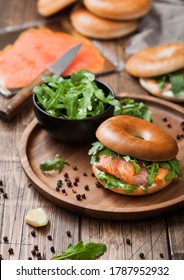 Fresh Healthy Organic Sandwich With Bagel And Salmon, Cream Cheese And Wild Rocket In Bowl With Bread And Smoked Salmon Pack On Wooden Background.