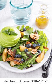 Fresh Healthy Salad With Leafy Greens, Plums, Nuts And Apple