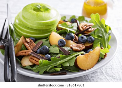 Fresh Healthy Salad With Leafy Greens, Plums, Nuts And Apple