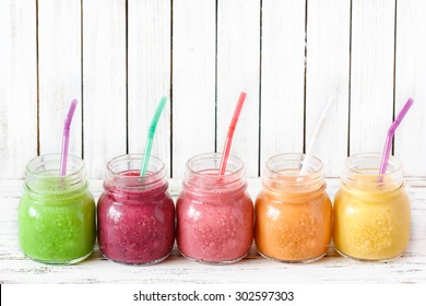 Fresh healthy smoothies with straws on a kitchen board. - Powered by Shutterstock