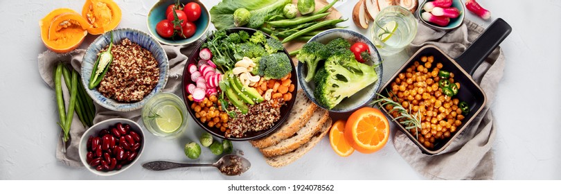 Frischer und gesunder veganischer Tisch mit Kichererbsen, Buddha-Schüssel, Kürbis, Broccoli, Quinoa, Keim und andere. heller Hintergrund. Draufsicht, Panorama-Banner