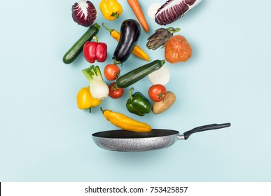 Fresh healthy vegetables falling in a pan, healthy food and cooking concept