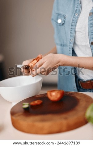 Fresh and Healthy Vegetarian Salad Preparation on a Wooden Cutting Board by a Woman Chef, with Emphasis on Freshness and Natural Ingredients