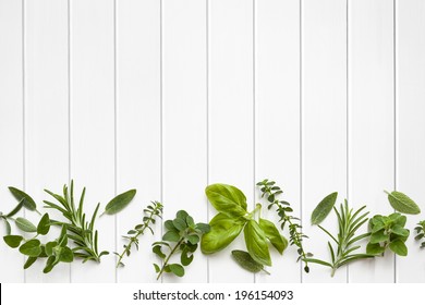 Fresh Herbs Border Over White Timber Panel Background.