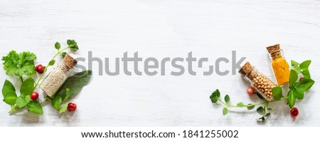 Fresh herbs and spices in small jars on white copy space
