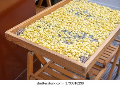 Fresh Home Made Italian Orecchiette Pasta On A Wooden Table On The Street In The Apulia (Puglia) Region