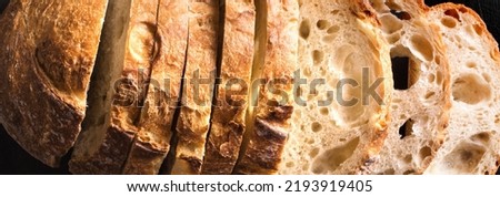 Fresh homebaked artisan sourdough bread. Texture of sliced loaf of bread close up, banner.