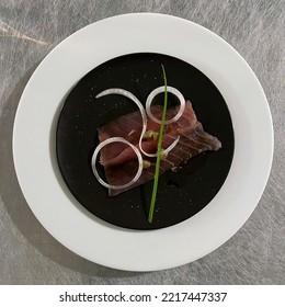 Fresh Homemade Ahi Tuna Carpaccio On A Black Plate Over A White Plate