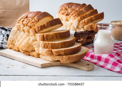 Fresh homemade  baked bread and sliced bread with milk on rustic white wooden table - Shutterstock ID 755588437