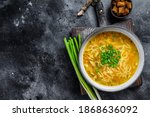 Fresh homemade chicken soup with noodle at table. Black background. Top view. Copy space