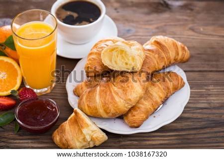 Fresh homemade croissants with black coffe and orange juice