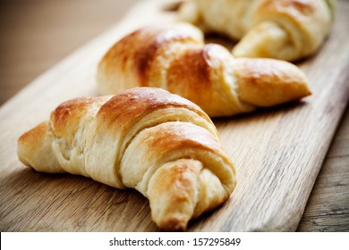 Fresh homemade croissants on wooden table, selective focus - Powered by Shutterstock