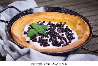 Fresh Homemade Dutch Baby Pancake With Greek Yogurt And Frozen Blueberries