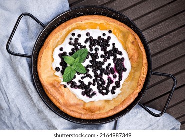 Fresh Homemade Dutch Baby Pancake With Greek Yogurt And Frozen Blueberries