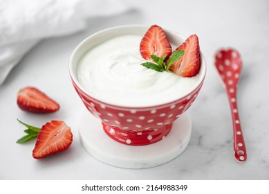 fresh homemade greek yogurt with fresh strawberries in a red bowl, close-up - Shutterstock ID 2164988349