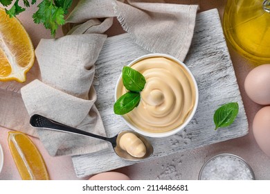 Fresh homemade mayonnaise with basil, lemon and butter on a light background. Mayonnaise sauce. - Shutterstock ID 2114486681