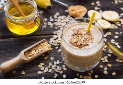 Fresh homemade nutritional smoothie with banana, oat flakes and peanut butter on rustic wooden background with ingredients. Healthy breakfast. Selective focus.  - Powered by Shutterstock