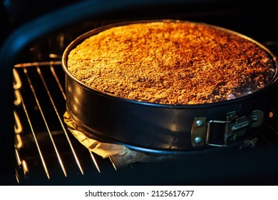 Fresh homemade pie in a special baking dish in an electric oven in the kitchen. View of a baked hot pie with the oven door open. Delicious apple dessert cake.