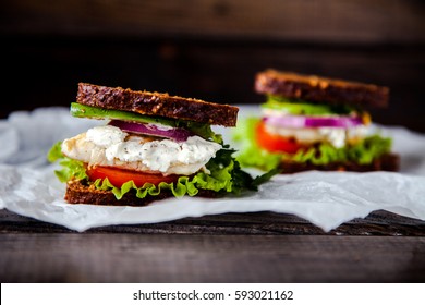 Fresh Homemade Sandwich With Cereals Dark Rye Grain Bread, Salad Lettuce, Avocado, Tomato, Grilled Chicken Breast, Curd Cheese, Onion And Greengrocery On Paper. Healthy Lifestyle Breakfast And Snack. 