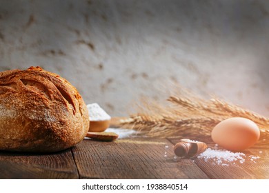 Fresh homemade sourdown bread, egg, flour on a wooden board with a gray background. Copy space for text. - Powered by Shutterstock