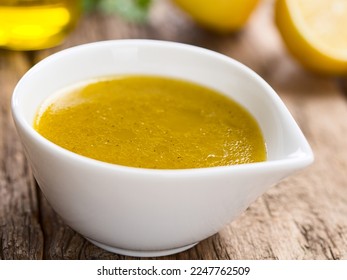 Fresh homemade vinaigrette salad dressing made of olive oil, lemon juice, salt and pepper (Selective Focus, Focus one  third into the vinaigrette) - Powered by Shutterstock