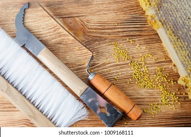 Fresh honey in the comb and the tools of the beekeeper on a brawn vooden background. Flat lay and top view. - Shutterstock ID 1009168111