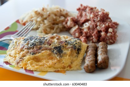 A Fresh Hot Breakfast Of Egg Omelet, Sausage, Hash Browns, And Corned Beef