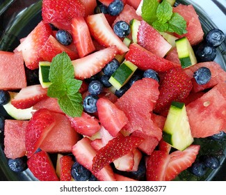 Fresh hydrating fruit on plate, watermelon, strawberries, blueberries, cucumber slices and mint leaves. Hydrating fresh fruit on a hot day.  - Powered by Shutterstock