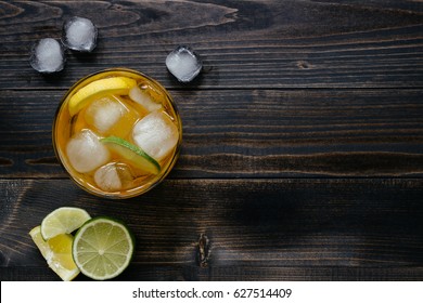Fresh ice drink with lemon and lime on the wooden table, top view. With copy space.