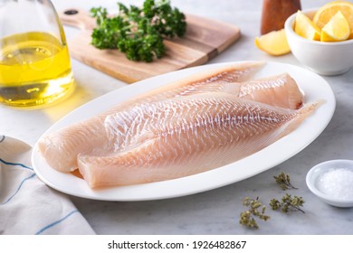 Fresh Icelandic Haddock Fillets on a plate with lemon and parsley.