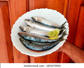 Fresh Indian Oil Sardine (Sardinella Longiceps) Isolated On White Background. Man Holding Fish On Hand/fish On Bowl. Indian Man Holding Fish With Hand