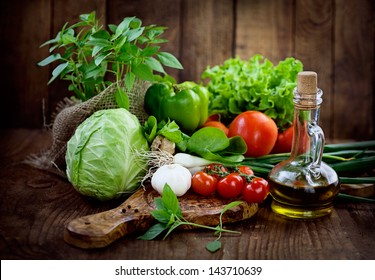 Fresh ingredients for cooking in rustic setting: tomatoes, basil, olive oil, garlic and onion,cabbage,letttuce - Powered by Shutterstock