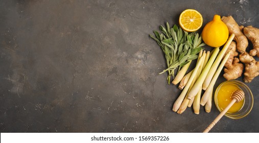 Fresh ingredients ginger, lemongrass, sage, honey and lemon for healthy antioxidant and anti-inflammatory ginger tea on dark background with copy space. Top view.
