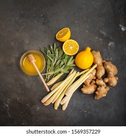 Fresh ingredients ginger, lemongrass, sage, honey and lemon for healthy antioxidant and anti-inflammatory ginger tea on dark background with copy space. Top view.