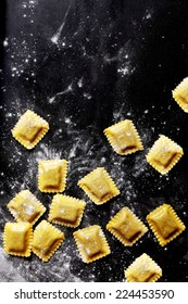 Fresh Italian Pasta Sheets Stuffed With Fillings. Formed In Square Shapes. Captured On Black Table.