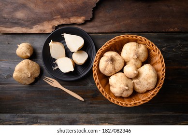 Fresh jicama or yam bean on wooden background. Jicama can be eaten raw or cooked, The taste are crisp, juicy, moist, and slightly sweet