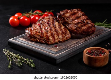 Fresh Juicy Delicious Beef Steak On A Dark Background. Meat Dish With Spices And Herbs