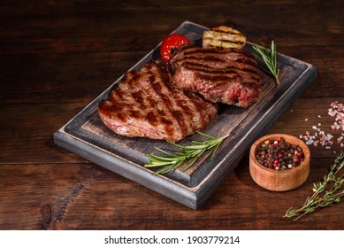 Fresh Juicy Delicious Beef Steak On A Dark Background. Meat Dish With Spices And Herbs