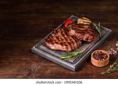 Fresh Juicy Delicious Beef Steak On A Dark Background. Meat Dish With Spices And Herbs