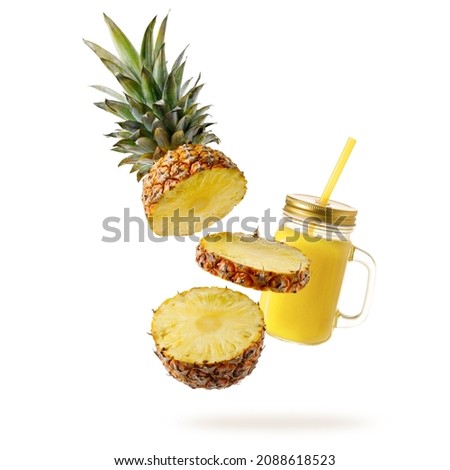 Fresh juicy tropical fruit pineapple  and smoothie glass jar flying isolated on white background. Sliced ananas pineapple and juice  falling.