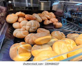 Fresh kaiser roll breads are lying in a self service supermarket shelf and are ready to be sold