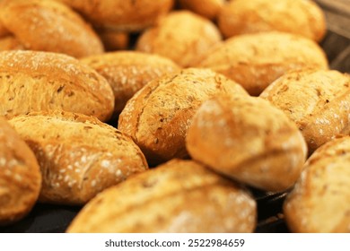 Fresh Kaiser rolls stacked on a store shelf. Group of classic bread rolls on display. Bakery section with a pile of golden brown buns. Perfect for sandwiches or breakfast. Crisp, freshly baked roll.