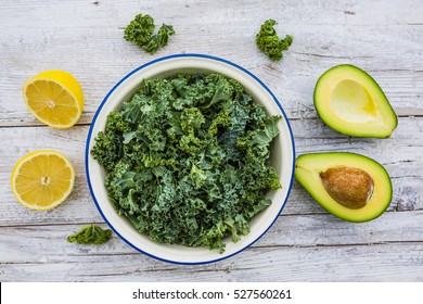 Fresh kale leaves and avocado on a wooden table.The raw ingredients for a salad. - Powered by Shutterstock