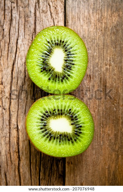 Fresh Kiwi Fruits Sliced on Wood Table Background,\
Rustic Still Life Style.