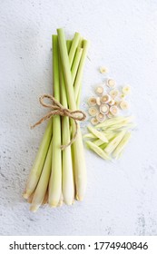 Fresh lemongrass rope and lemongrass slices on white marble background, cooking concept